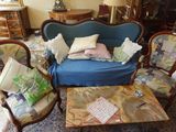 un canapé bleu placé dans un salon, à côté d'une table basse