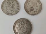 trois types différents de pièces d'argent sur une surface blanche