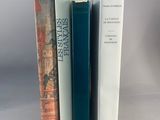 trois livres posés l'un à côté de l'autre sur une table