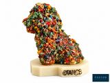un petit chien fait de bonbons posé sur un bloc