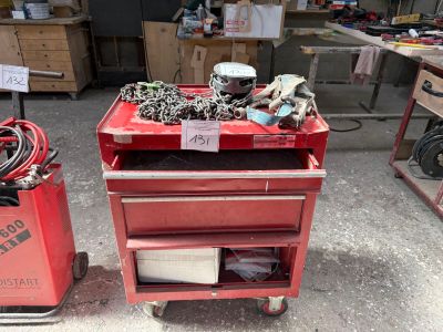 un chariot à outils rouge sur lequel se trouvent de nombreux outils