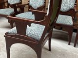 four wooden chairs with blue upholstered cushions sit in a room
