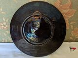 a black plate with a picture of a woman on it