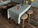 a table with a blue and white checkered tablecloth and four stools
