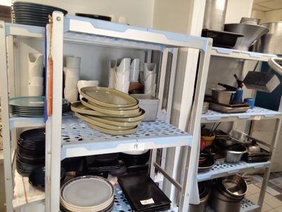 beaucoup d'assiettes et de casseroles sur les étagères de la cuisine