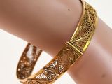 a close up of a gold bracelet on a mannequin arm