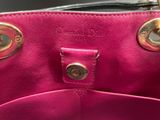 a close up of a pink purse with gold handles