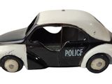 une petite voiture de police posée sur une surface blanche