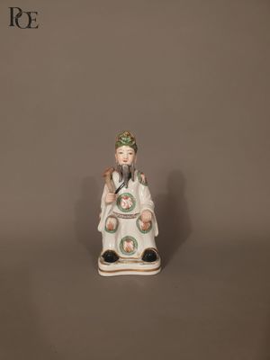 porcelain figurine of a woman sitting on a stool with a bird in her hand