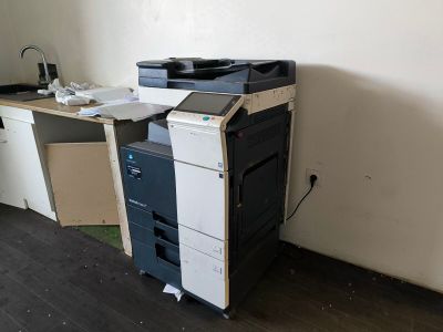 a black and white printer sitting on top of a wooden desk