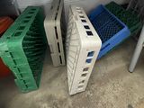 several plastic crates are lined up against a wall in a garage