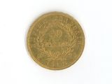 a gold coin on a white surface with a white background
