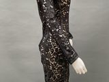 a mannequin wearing a black lace dress with long sleeves