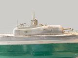 a model of a green and white boat in the water