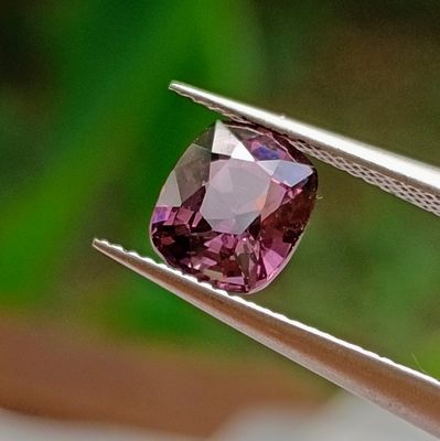 someone is holding a pair of pliers with a pink diamond in it