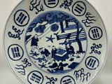 une assiette bleue et blanche ornée de symboles asiatiques