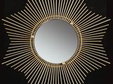 un miroir doré à rayons de soleil sur fond noir