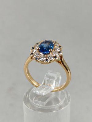 un gros plan d'une bague en or sertie d'un saphir bleu et de diamants blancs