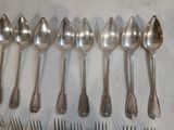 un grand nombre de cuillères et de fourchettes disposées sur une table