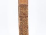 an old book sitting on top of a table next to a white wall