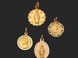un ensemble de quatre pendentifs en or représentant la Vierge de Guadalupe