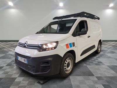 la camionnette blanche est garée dans une pièce au sol en damier