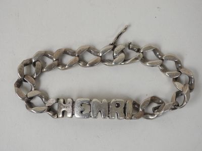 un gros plan sur un bracelet en argent sur lequel est gravé un prénom