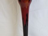 a black and red vase sitting on a white surface