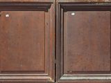 two wooden doors that are open on the side of a building