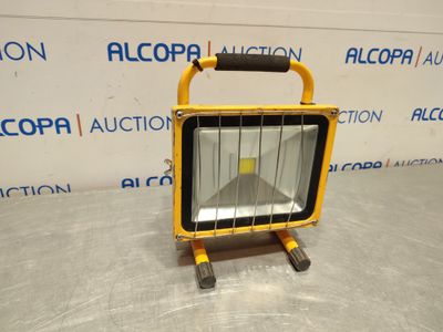 un projecteur jaune posé sur une table en métal