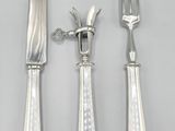 three pieces of silverware including a knife, fork and spoon