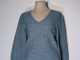 the top of a mannequin torso with a blue sweater on it