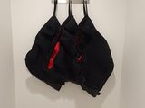two bags hanging on a hook in the corner of a room