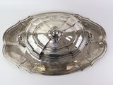 a silver plate with a clock on it sitting on a table