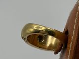 a gold ring sitting on top of a brown bag