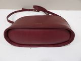 a close up of a red handbag on a white surface
