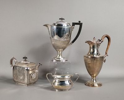trois vases en argent et deux théières en argent posés sur une table
