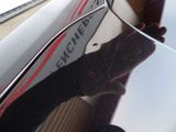reflection of a person holding a surfboard on the side of a boat