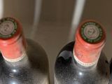 four bottles of wine are lined up in a row on a counter