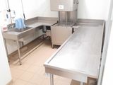 une cuisine équipée de plans de travail en inox et d'un évier