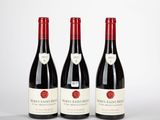 trois bouteilles de vin posées sur une table l'une à côté de l'autre