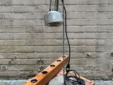 a small table with a lamp on it next to a brick wall