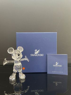 La figurine est posée sur la table, à côté de la boîte.