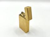 a gold lighter that is sitting on a white surface