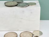 un bloc de marbre blanc sur lequel sont posées des pièces de monnaie