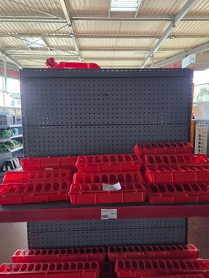 many red bins on the shelf in the store