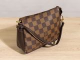 a brown and black purse sitting on top of a wooden table
