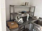 a small kitchen with a sink and a metal counter