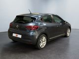 the back end of a grey car in a room with a black floor