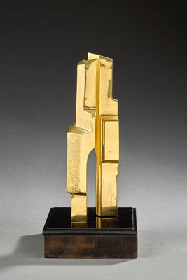 sculpture of a golden sculpture on a wooden base on a gray surface